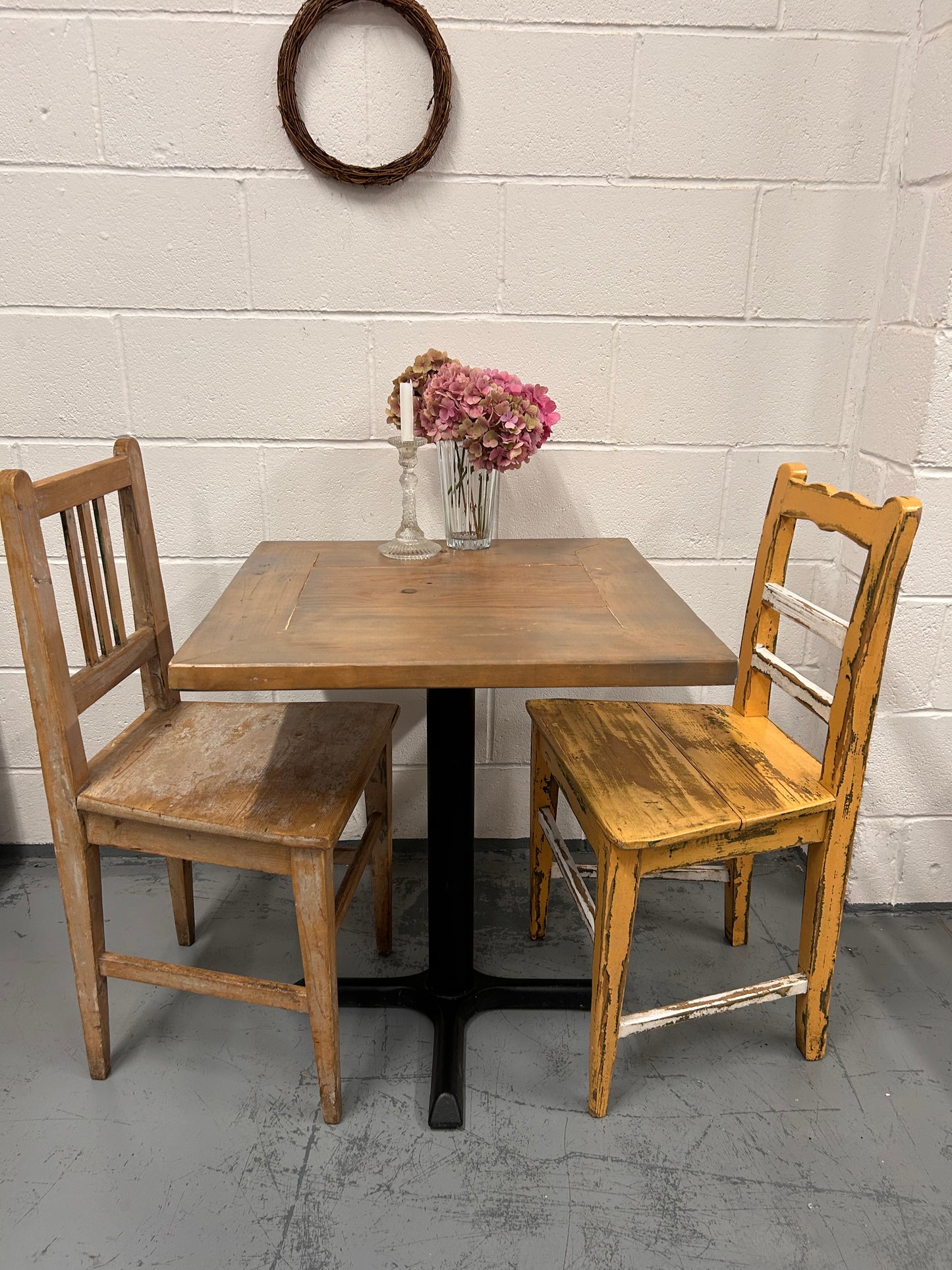 Rustic Preloved two seater table with thick wooden top and black metal base.