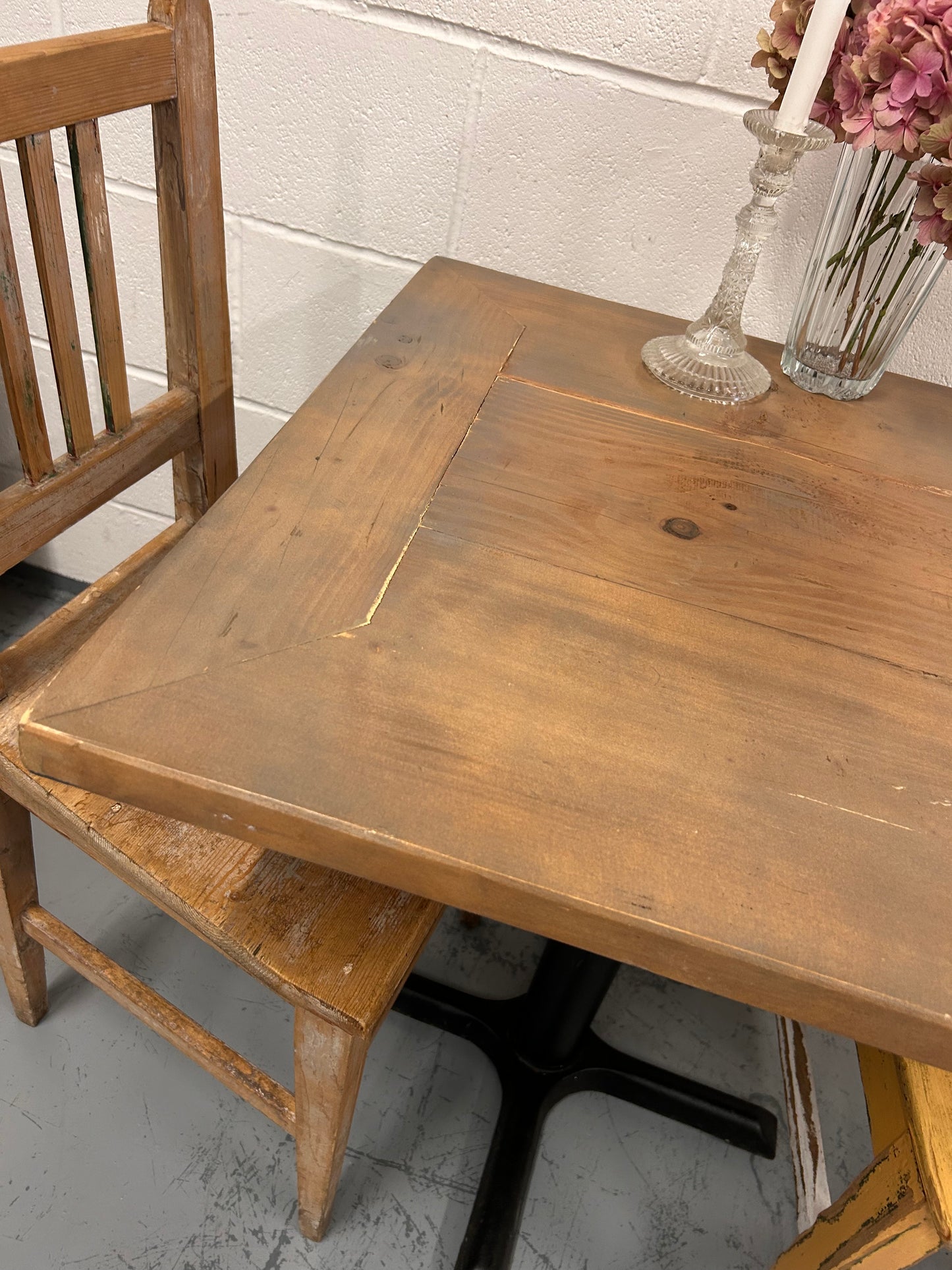 Rustic Preloved two seater table with thick wooden top and black metal base.