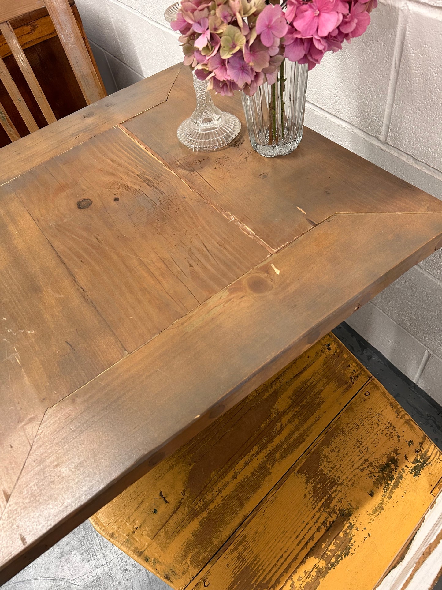 Rustic Preloved two seater table with thick wooden top and black metal base.