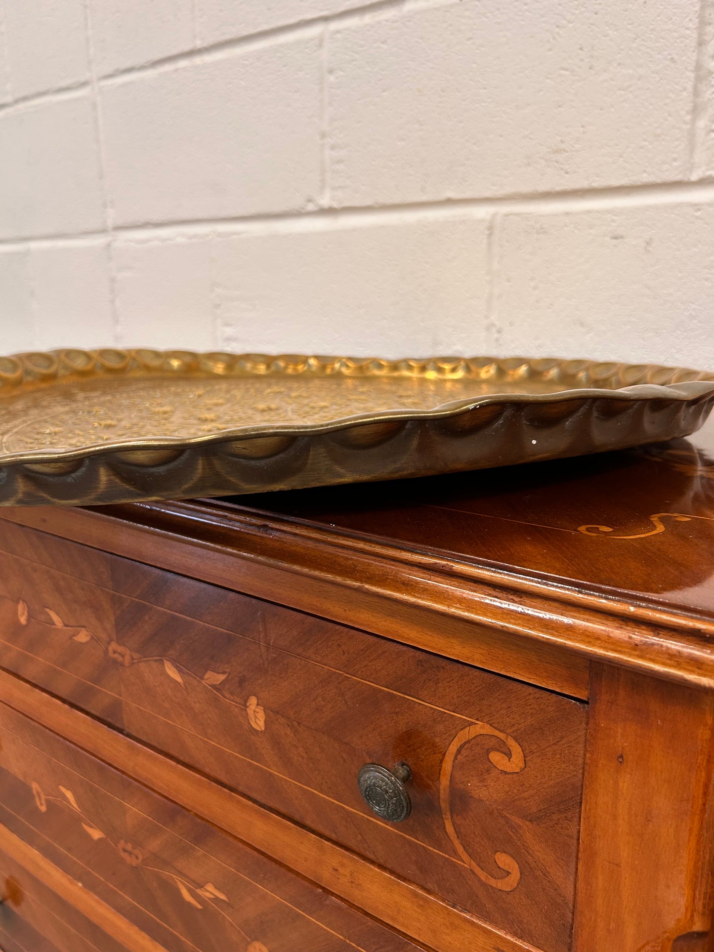 A large brass eastern charger with embossed foliate design