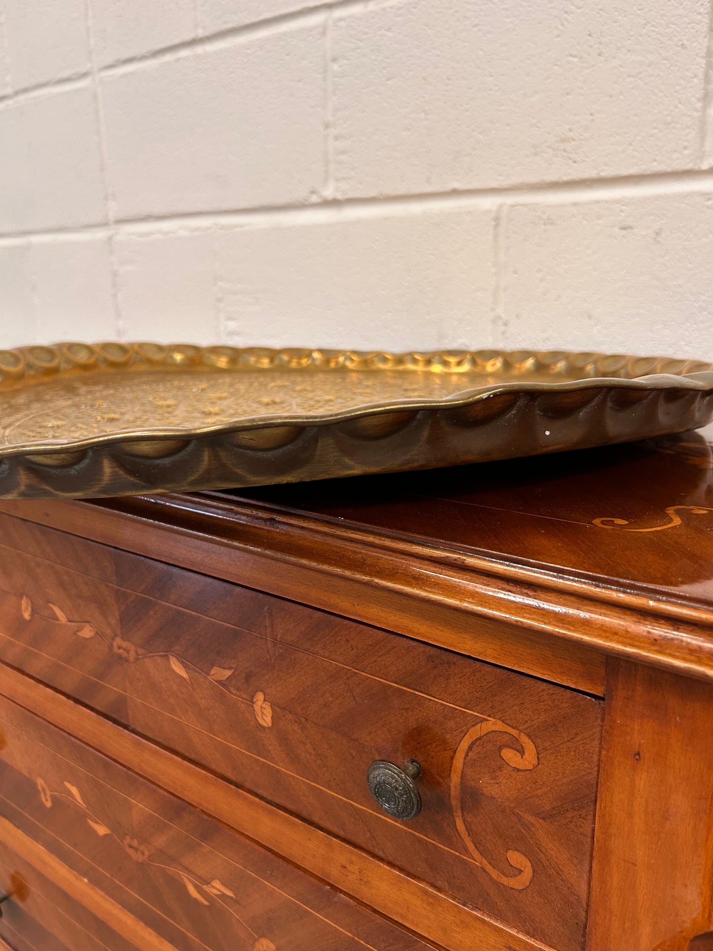 A large brass eastern charger with embossed foliate design