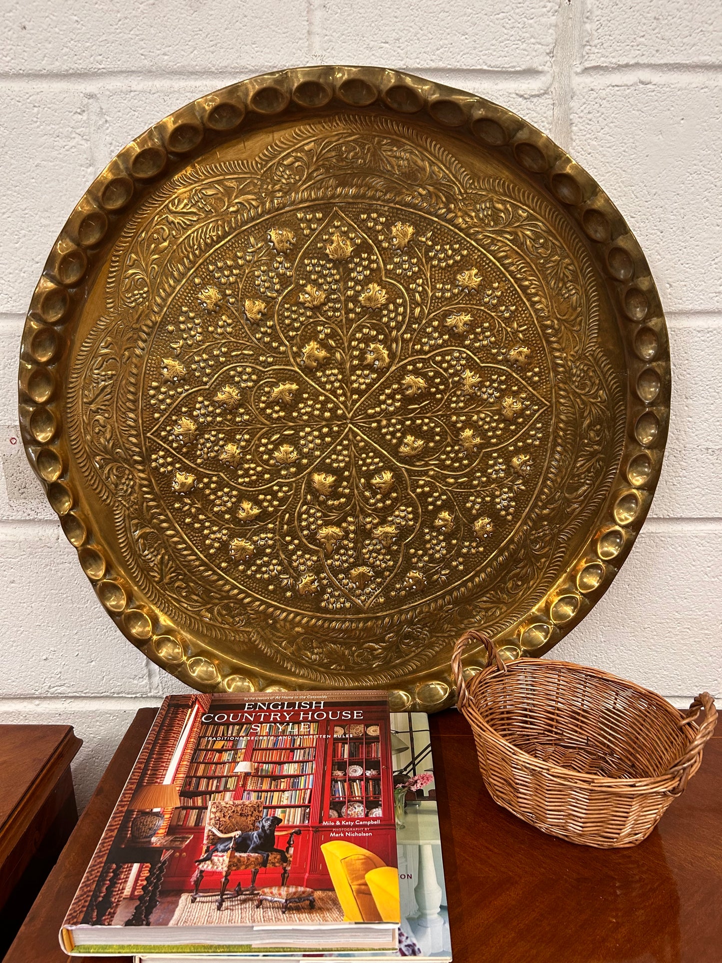 A large brass eastern charger with embossed foliate design