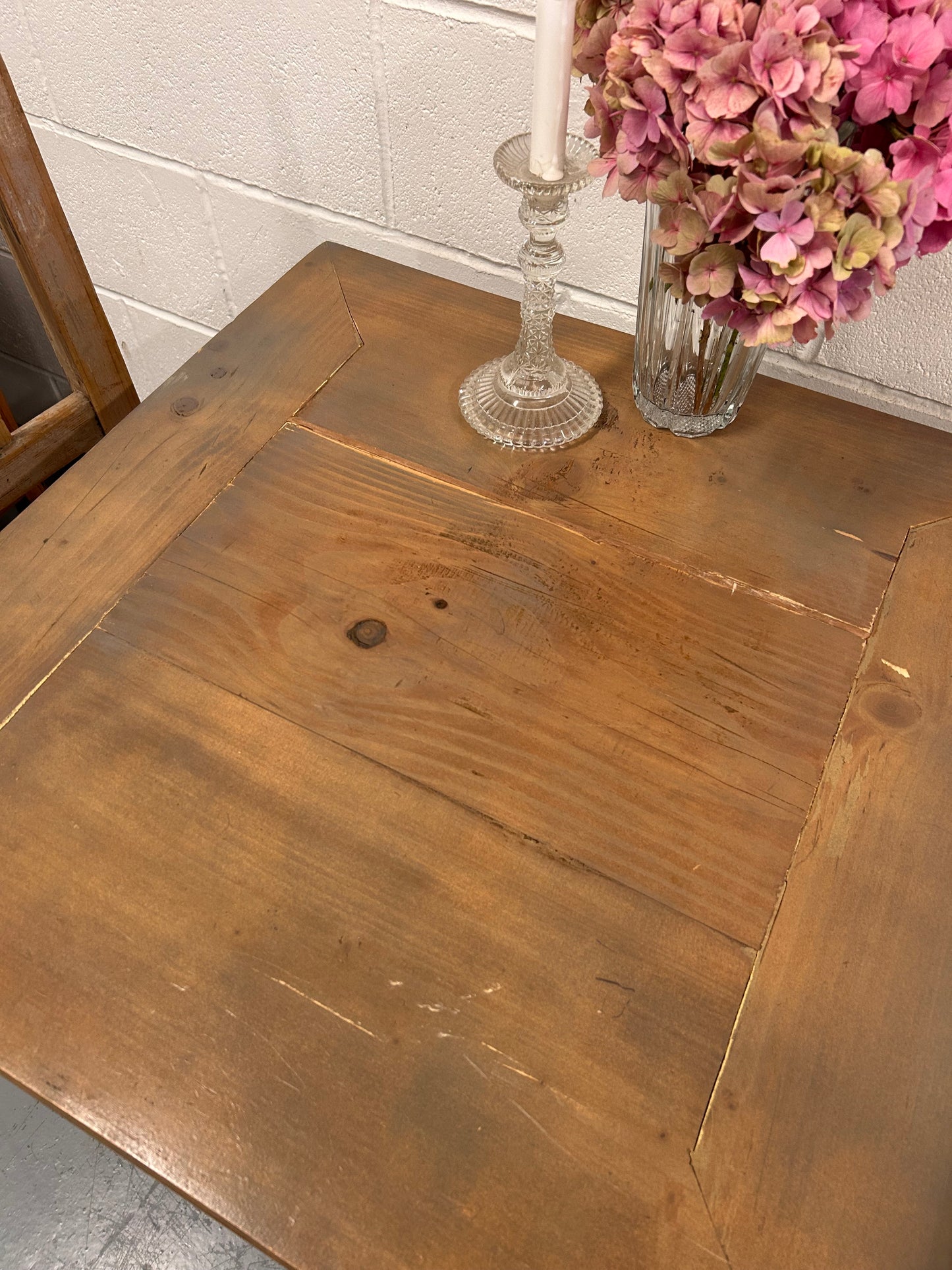 Rustic Preloved two seater table with thick wooden top and black metal base.
