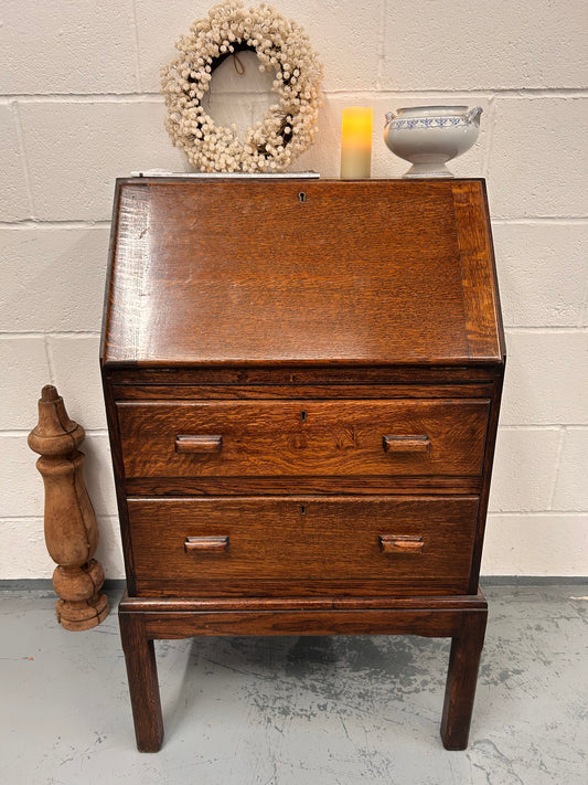 A lovely little vintage compact oak bureau with drop down writing surface and storage