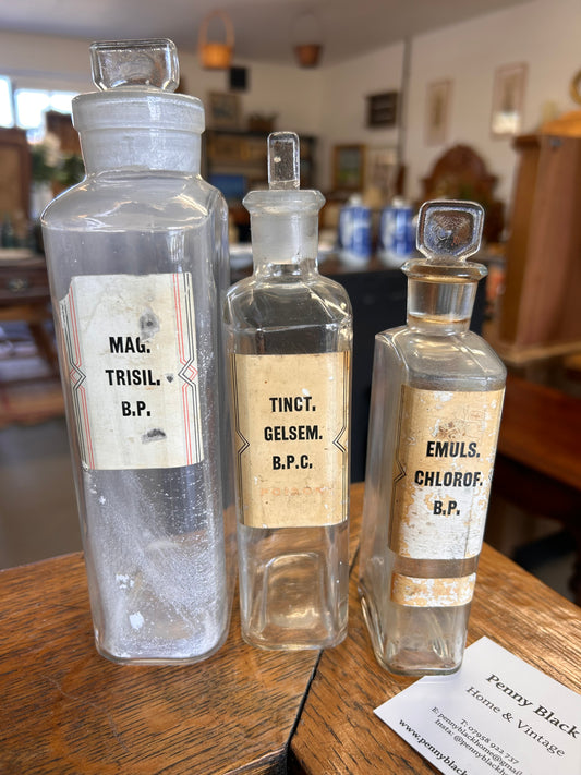 Three Victorian apothecary chemists bottles with labels and ground glass stoppers.