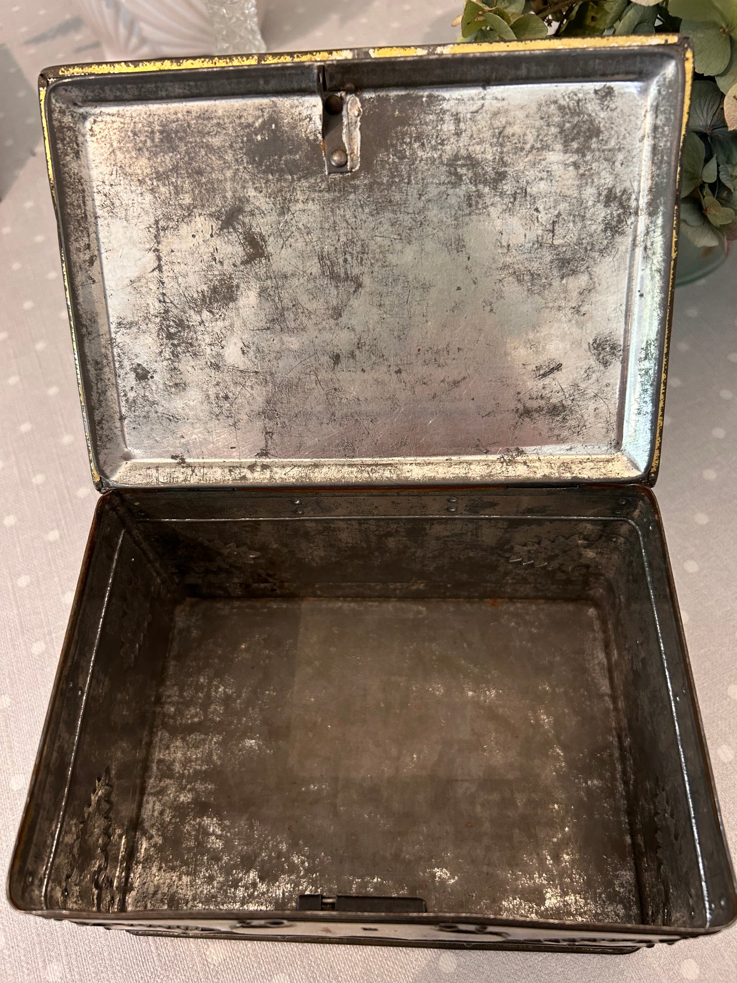 A vintage metal tin storage box resembling brass mounted wood.