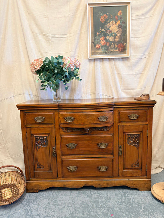 Edwardian Walnut sideboard featuring carved floral panels doors and brass hardware