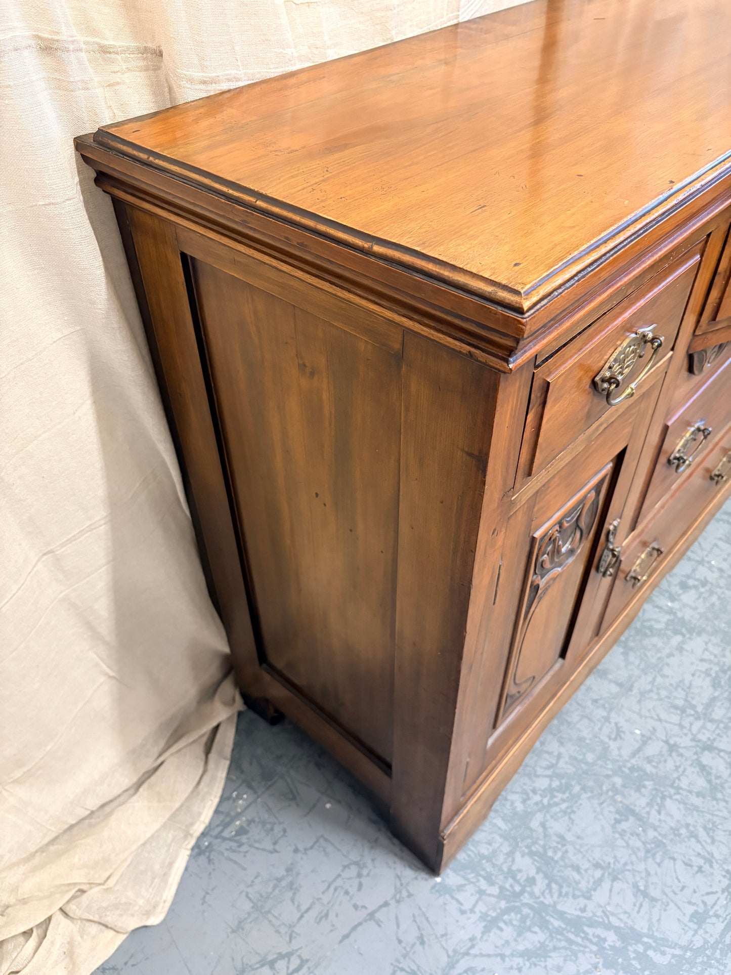 Edwardian Walnut sideboard featuring carved floral panels doors and brass hardware