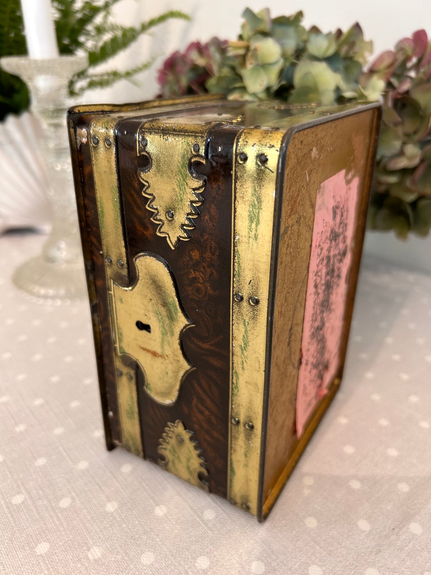 A vintage metal tin storage box resembling brass mounted wood.