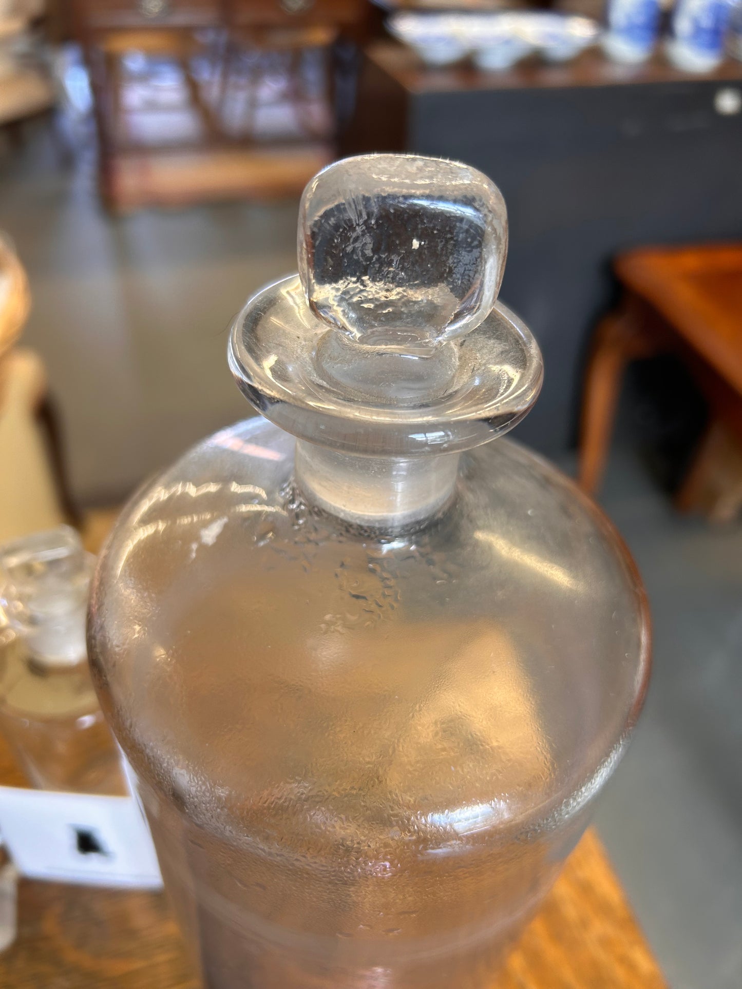 One large plain glass apothecary bottle with ground glass stopper.