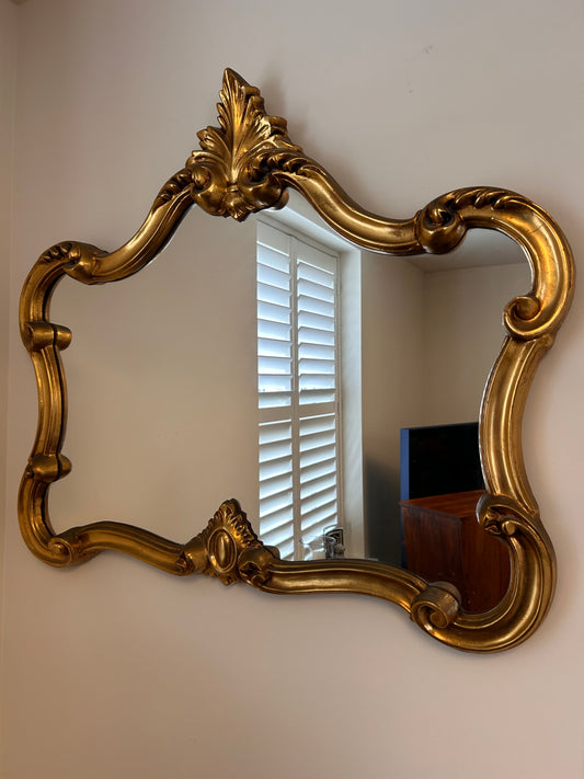Vintage Giltwood baroque design wall mirror with carved frame detailing.